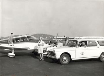 Vue ancienne du tarmac de l'aéroport avec un avion et quelques passagers